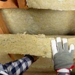 pest control technician inspecting attic insultation for pest infestation